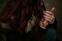 Crop ginger girl lighting up cigarette — Stock Photo