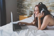Woman in headphones using laptop — Stock Photo