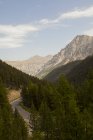 Мальовничий пейзаж з велосипедистами силуети на звивистій дорозі в горах — стокове фото