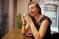 Жінка має каву в кафетерії — стокове фото