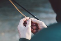 Crop male handspreparing hook for fishing — Stock Photo