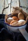 Still life of eggs on sacking in metal scoop — Stock Photo