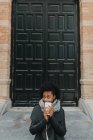 Menina retrato no casaco posando com xícara de café sobre fachada edifício — Fotografia de Stock