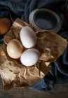 Directamente encima de la vista de los huevos sobre papel marrón - foto de stock