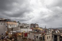 Vista de ángulo alto de casas en mal estado bajo duras nubes - foto de stock