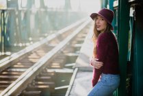 Chica en el puente ferroviario y mirando a la cámara - foto de stock