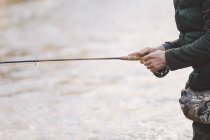 Midsection of man fishing with rod on river — Stock Photo