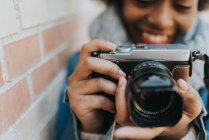 Крупним планом вид усміхненої дівчини фотографується з аналоговою камерою — стокове фото