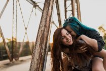 Mädchen reißt Freundin auf Rücken an Brücke — Stockfoto
