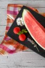 Coin de pastèque fraîche et fraises sur ardoise — Photo de stock
