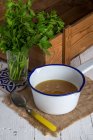 Schüssel mit Suppe und Glas mit Petersilie — Stockfoto