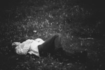 Girl in white sweater lying on ground at countryside — Stock Photo