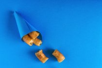 Churros em cone de papel em azul — Fotografia de Stock
