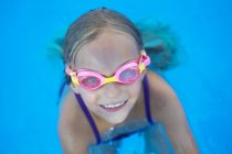 Cheerful kid in goggles at swimming pool — Stock Photo