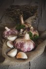 Натюрморт спелый и свежий чеснок на деревенском мешке — стоковое фото