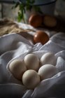 Still life of chicken eggs on white towel — Stock Photo
