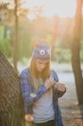 Retrato de menina com chapéu de lã engraçado posando na floresta e olhando para baixo — Fotografia de Stock