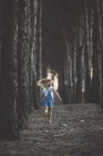 Visão traseira da criança loira correndo na floresta — Fotografia de Stock