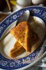 Vista da vicino del piatto in ceramica decorato con triangolo toast dolci e cucchiaio — Foto stock