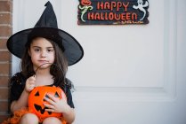 Fille en costume de sorcière assis sur le porche — Photo de stock