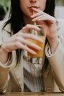 Крупный план женщины, пьющей апельсиновый сок — стоковое фото