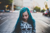 Расстроенная девушка с голубыми волосами на городской сцене — стоковое фото