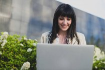 Woman using laptop at outdoor urban scene — Stock Photo