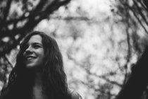 Fröhliches Mädchen, das vom Wald wegschaut — Stockfoto