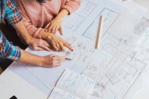 Male hands pointing with pencil on blueprints — Stock Photo