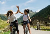 Girls on bikes giving high five — Stock Photo