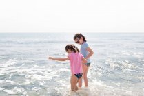Sisters playing on the beach and holding hands. — Stock Photo
