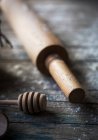 Close-up vista de colher de mel de madeira e rolo de pino na mesa rústica — Fotografia de Stock