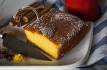 Натюрморт из лимонного пирога на тарелке с ножом на полотенце — стоковое фото