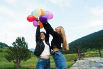 Festive women with balloons at nature — Stock Photo