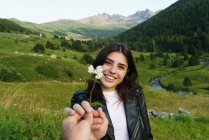 La mano del fotógrafo de la cosecha dando flor a la niña en la naturaleza - foto de stock