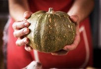 Close-up of female hands holding fresh pumpkin — Stock Photo