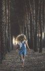 Visão traseira da criança feliz correndo na floresta — Fotografia de Stock