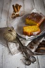 Высокоугловой вид ломтиков лимонного пирога на тарелке над столом с палочкой сельских ниток и ножниц — стоковое фото