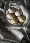 White chicken eggs on towel — Stock Photo