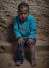 Арабский мальчик сидит и смотрит в камеру — стоковое фото
