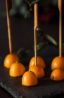 Primo piano di kumquat freschi dimezzati su bastoni su ardesia — Foto stock