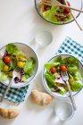 Directly above view of bowl and plates with salad served on table — Stock Photo