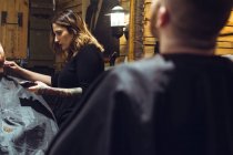 Donna taglio di capelli un uomo — Foto stock