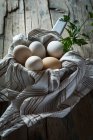Still life of chicken eggs  towel and scoop on rural table — Stock Photo