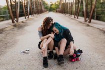 Mädchen sitzen auf Skateboard und lachen — Stockfoto