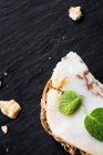 Сэндвич с солоноватым беконом и мятными листьями на доске — стоковое фото