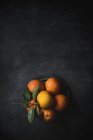 Tangerines with leaves on table — Stock Photo