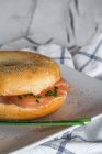 Crop delicious bagel with salmon and cheese on plate — Stock Photo