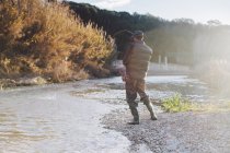 Vue arrière de la pêche avec canne à pêche à la rivière contre paysage d'automne — Photo de stock