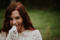 Süßes Ingwermädchen blickt in die Kamera und lächelt — Stockfoto